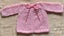 HAND KNITTED BRIGHT PINK 4 PLY LACY JACKET. Carousel 1