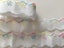 White cotton broderie anglaise trim with variegated edge Carousel 2