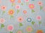 Turquoise fabric decorated with various coloured flowers Carousel 1