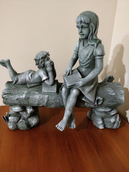 Unusual sculpture of 2 children on a log -joy of storytelling Carousel 1