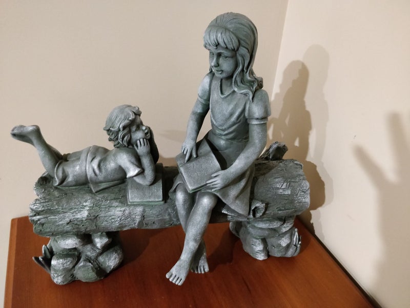 Unusual sculpture of 2 children on a log -joy of storytelling Carousel 2