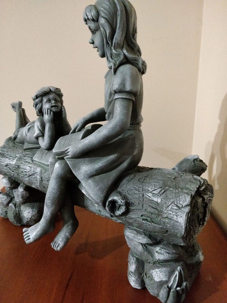 Unusual sculpture of 2 children on a log -joy of storytelling Carousel 5