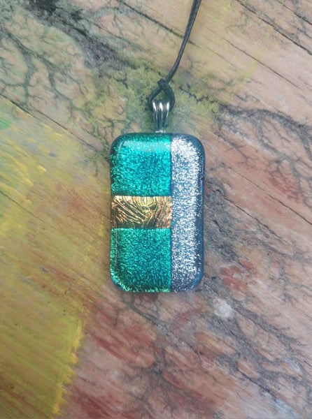 Green & silver metallic foil art glass pendant on new waxed cord. Carousel 2