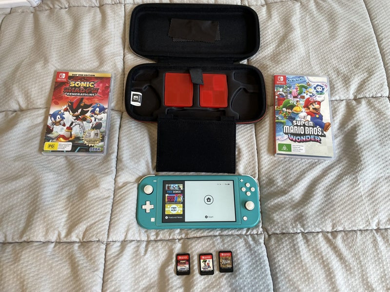 Turquoise Nintendo Switch Lite plus three games and case Carousel 1
