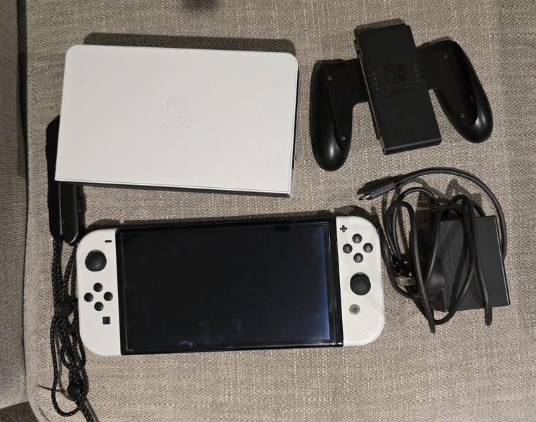 White Nintendo Switch OLED with screen protector, case, and handheld controller Carousel 1