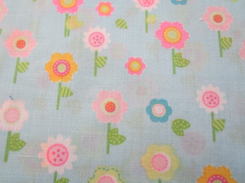 Turquoise fabric decorated with various coloured flowers Carousel 1
