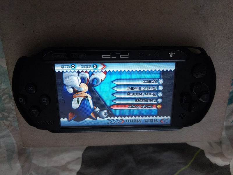 PSP, original charger, 4GB storage card and 9 Games Carousel 2
