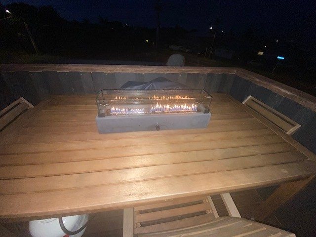 Outdoor entertainment table on lockable wheels, with chairs, gas fire, cover.64473890471938114