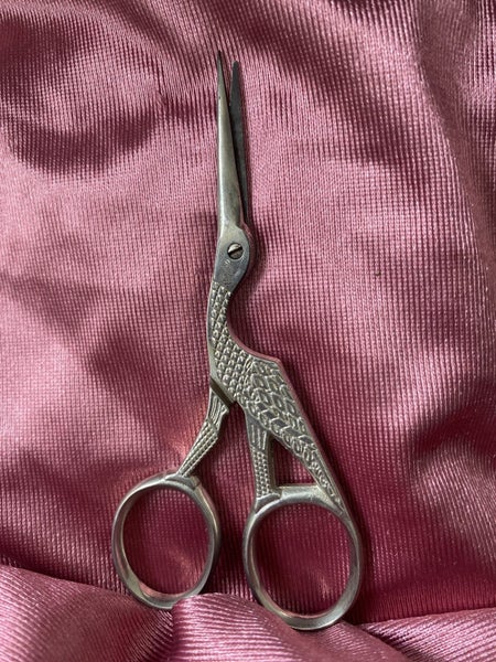 pair of stork embroidery scissors, a common tool in sewing and needlework. Carousel 3