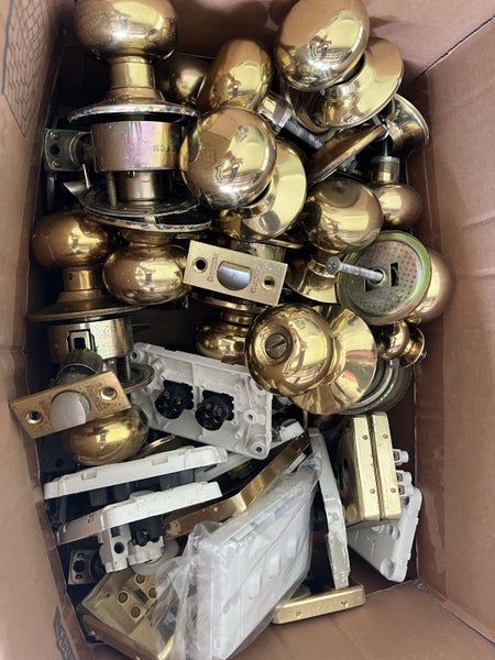 Box of gold door knobs and light switch covers Carousel 2